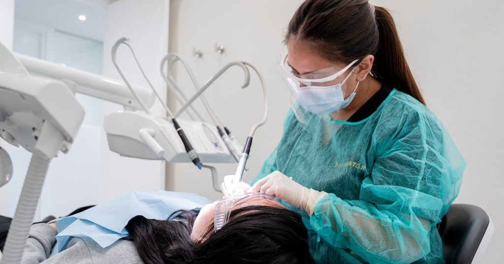 Odontóloga de DentalStar atendiendo a una paciente en el sillón clínico durante un tratamiento con anestesia local